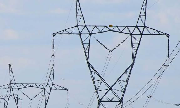 Power lines and relay station with sky behind them