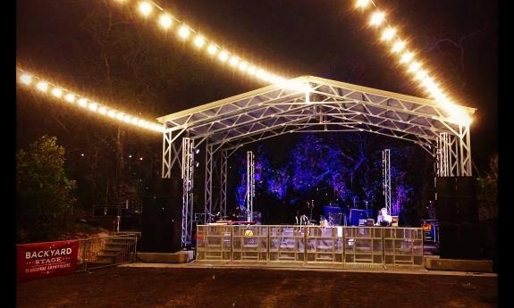 The Backyard Stage at the Amphitheatre, lit for an act performing at night.