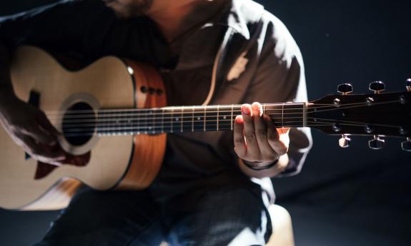A man plays his guitar. 