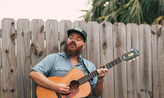 Kirk Whalen singing and playing his guitar.