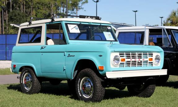 An older aqua-colored Ford vehicle at an auto show