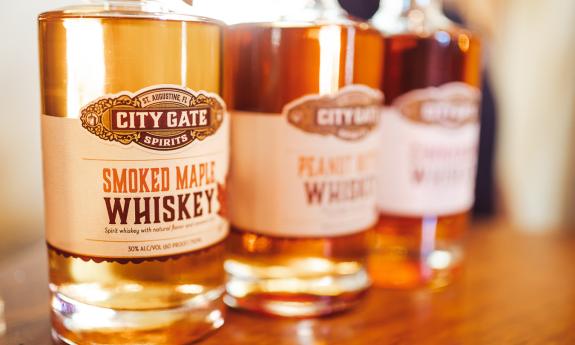 A trio of City Gate Spirits whiskies, each a different type, on a wooden counter