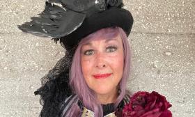 A close-up photo of a woman with a fancy hat and steampunk garb