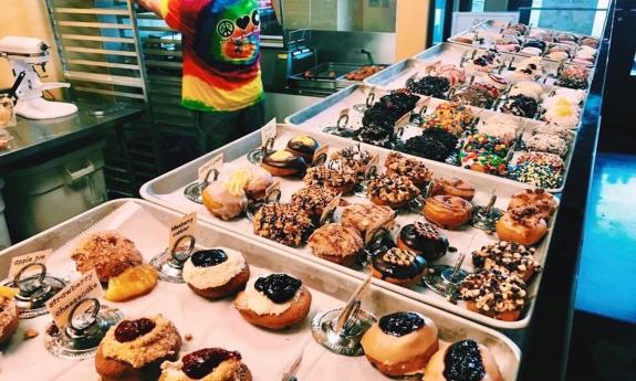 Peace, Love and Little Donuts of St. Augustine displaying trays of donuts.