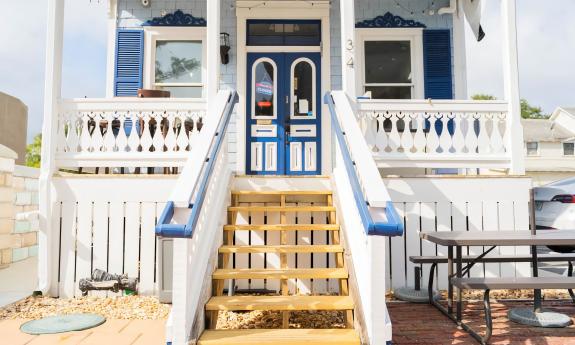 Steps leading up to the porch of a blue-painted restaurant