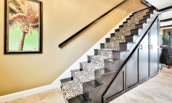 The interior of a condo on the beach with a stairway to the second floor