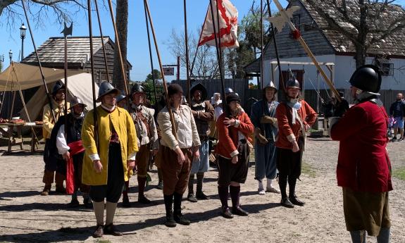 A muster of soldiers of the 16th century flying the Spanish flag