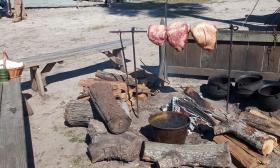 Meat roasting over a fire at the School of the 16th Contrary encampment in St. Augustine