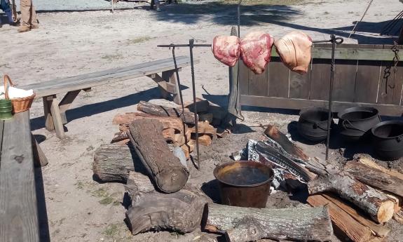 Meat roasting over a fire at the School of the 16th Contrary encampment in St. Augustine