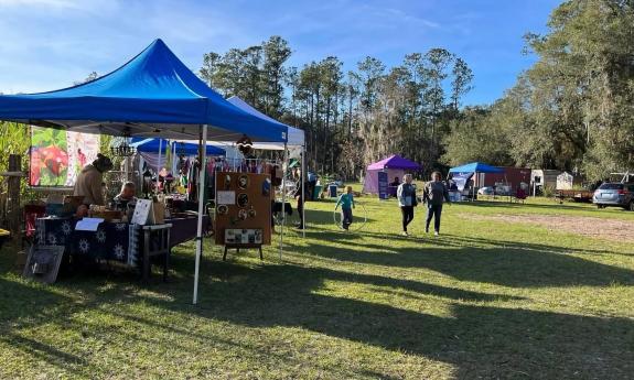 A wide photo including lawn and booths for the Holistic Gathering in Elton