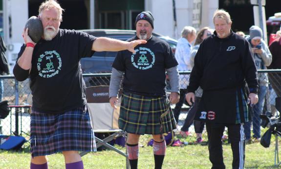 A man in a kilt competes in the stone put in the Celtic Games