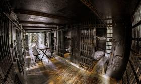 A fish bowl view of the inside of the Old Jail in St. Augustine, sunlight filtering through the metal bars