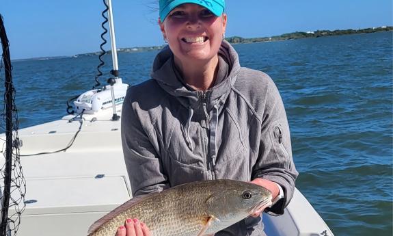 A young woman on the Aloha Fishing Charters boat holds the fish she caught in St. Augustine