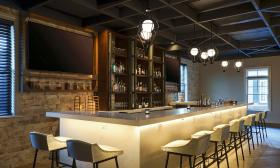 The view of the cream-colored bar with matching stools at the Renaissance Historic Downtown 