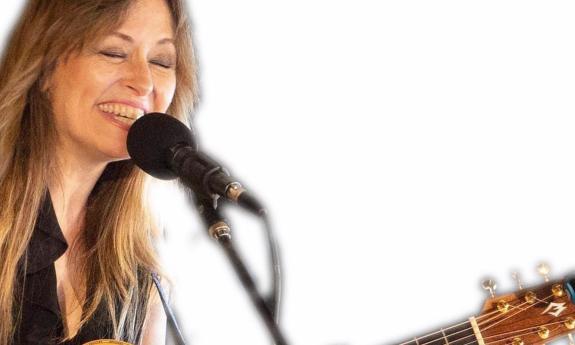 MIchelle Ingrhman with her guitar, singing and smiling