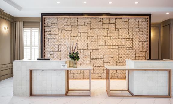 A stark white reception desk with brass trim, in a modern hotel lobby in St. Augustine