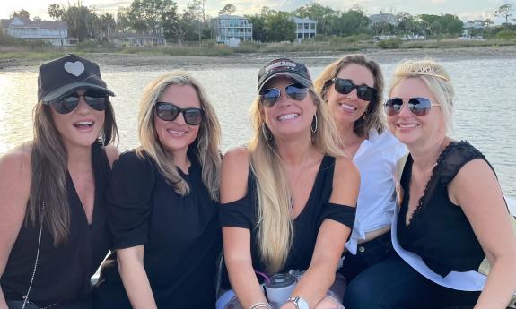 Four bridesmaids and the bride, all in black and white, aboard the Tiki Island Charter boat in St. Augustine