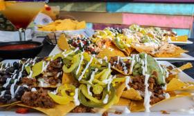 Cantina Louie's gravedigger nachos featuring ground beef, jalapeños, black bean salsa, onions, and a queso drizzle