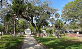 Live oak trees overhang gravestones and mausoleums at St. Augustine Florida's historic Tolomato Cemetery