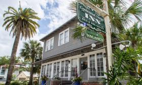 The historic Centennial House Inn Bed and Breakfast in St Augustine, flanked by colorful plantings and palm trees