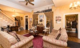 The warm, welcoming living room area, with hand painted gold-tone walls, and comfy sofas at Centennial House B n B in St Augustine