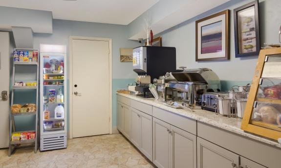 The breakfast and snack area at Ocean Sands Inn with a counter filled coffee and pastries