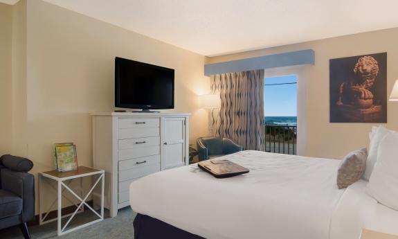 This second-floor room has on bed and a view of the ocean and beach