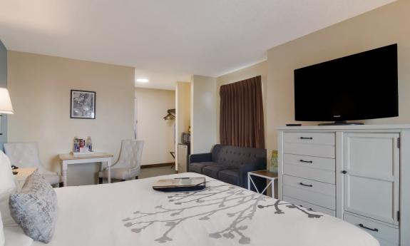 A bed with a white bedspread, with a grey appliqué, is shown in this room at Ocean Sands Inn