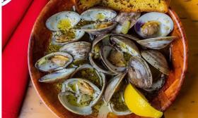 Clams gently drizzled with lemons are positioned in a basket