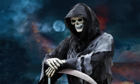 The grim reaper leans on his scythe, on a dark night with a full moon in the background
