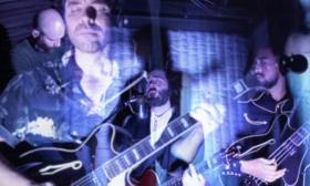 The four members of Lord Huron, superimposed over each other, playing their instruments