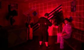 In a darkend room with red light, a guest interacts with a ghost during Ripley's Haunted Tour 