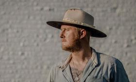 Singer-songwriter Styles Haury in hat looking sideways