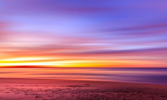 A bright and colorful sunset stretches across the horizon