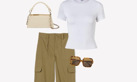 Wide cargo pants with a white shirt and a purse are positioned in front of a white background. 