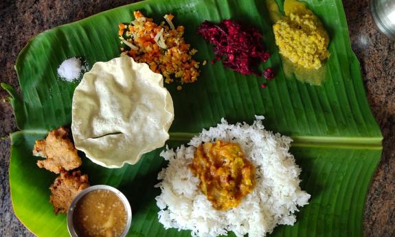 A variety of herbs, spices, and curry is positioned on a table for a customer. 