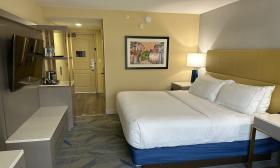 A guest room with a king bed, art, lamps and flat-screen TV at DoubleTree by Hilton on San Marco