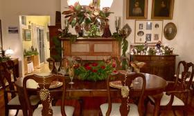 This dining room in an historic home is decorated for the holidays with gold accents