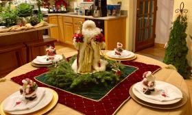The kitchen and dining nook have a Santa and greenery theme in this decorated home