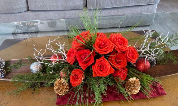 A bouquet of roses and gold-painted pine cones greet visitors at this home