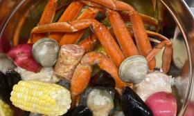 Crabs, mussels, and corn is in a pot. 