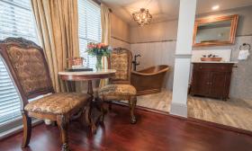The bathing area in the Victoria Room at the Bayfront Wescott House has a Victorian-era side table and chairs