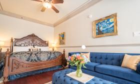 The bed and seating area in the Bayfront Westcott House has Victorian-style furnishings in blue