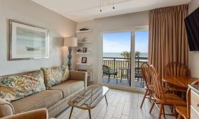 This patio suite at Beacher's Lodge has a soft sand and green decor and a view of the ocean