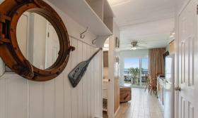 The hall in this patio suite at Beacher's Lodge has white paneling and nautical decor