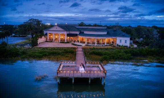 Newlyweds on the River House's wooden boardwalk the evening of the wedding