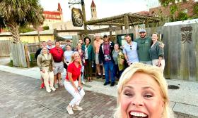 A tour group in front of Casa Vino, in a selfie pose created by the tour guide