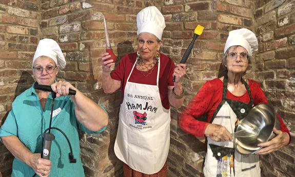 Three members of the Tale Tellers of St Augustine, in chef's hats and with kitchen tools
