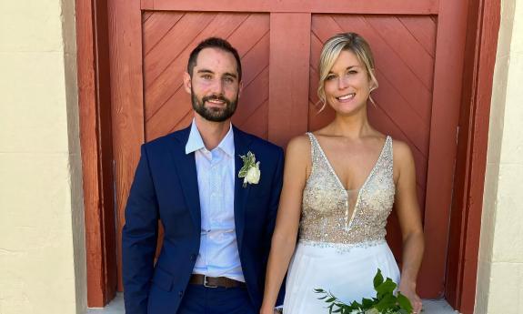 Bride and groom posing in front of a building