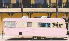 Bardot beauty trailer in front of yellow building